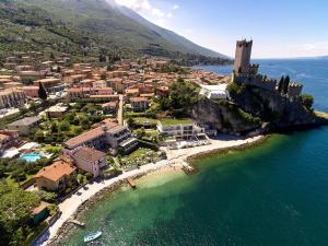 una vista aerea di una piccola città su un'isola rocciosa in acqua di Hotel Castello Lake Front a Malcesine