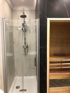 a shower with a glass door in a bathroom at Family & Business Sauna Apartments Paderewskiego Sienkiewicza No2 Centrum Downtown - 2 Bedroom with Private Sauna, Bath with Hydromassage, Parking in Kielce +122 photos