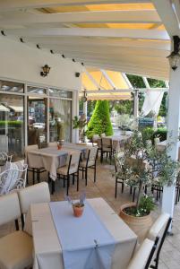 an outdoor patio with tables and chairs and windows at Polizotou Rooms in Skala Sotiros