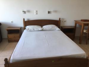 a bed with two pillows on it in a bedroom at Eugenia travasarou sea view appartments in Diakofti
