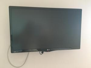 a flat screen tv hanging on a wall at Eugenia travasarou sea view appartments in Diakofti