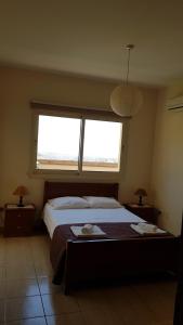 מיטה או מיטות בחדר ב-Lazaros Pissouri Apartments