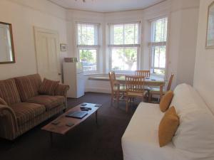 uma sala de estar com um sofá e uma mesa em Kenmuire Apartment em Weymouth