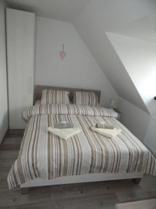 a bedroom with a bed with two pillows at Apartmán LEMON in Vysoke Tatry - Tatranska Lomnica.
