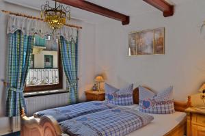 a bedroom with a bed with blue pillows and a window at Pension Fuhrmann's Elb- Café in Bad Schandau