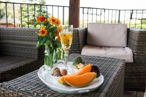 einen Tisch mit einem Obstteller und einem Glas Wein in der Unterkunft La Pieve in Arezzo