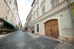 an empty street with a large wooden door on a building at ASAO-Apartments walking center zone in Lviv
