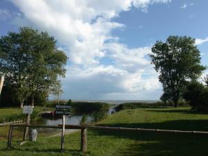 a view of a river with a boat on it at Landhaus am Haff_ Wohnung B 8 in Stolpe auf Usedom