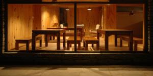 a dining room with wooden tables and benches in a room at Binsar Forest Retreat in Binsar