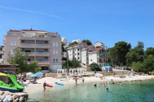 a group of people in the water at a beach at Apartments Villa Plaza in Trogir