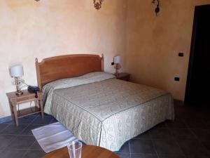 - une chambre avec un lit et 2 tables avec des lampes dans l'établissement Palazzo Marzano, à Briatico