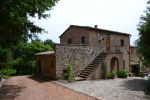 un vecchio edificio in mattoni con una scala sopra di Piccozzo agritour a Casciana Terme