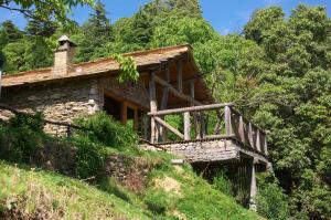 an old stone house on a hill with trees at Binsar Forest Retreat in Binsar