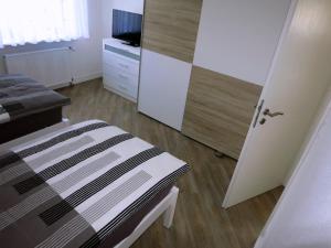 a bedroom with a bed and a tv and a door at Ferienwohnung Hamburg / Lüneburg in Scharmbeck