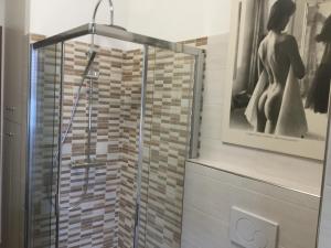 una ducha con puerta de cristal en un baño en Casa Laura, en Dormelletto