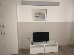 a living room with a tv on a white cabinet at Studio apartman Dado in Bale