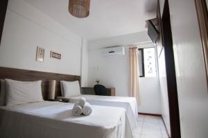 2 Betten in einem Hotelzimmer mit Handtüchern darauf in der Unterkunft Hotel Gogó da Ema in Maceió