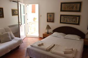a bedroom with a white bed and a couch at Old Town Apartment MARTIN in Budva