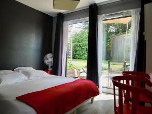 a bedroom with a bed and a sliding glass door at Les Cabanes de Do in Le Mans
