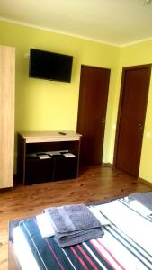 - une chambre avec un lit et une télévision murale dans l'établissement Casa Banc, à Baile Unu Mai