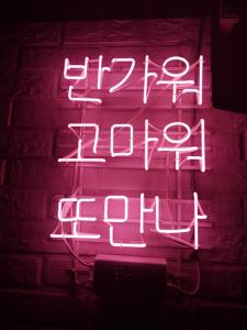 un cartel de neón que dice feliz fiesta en bloque en Family House Hongdae en Seúl