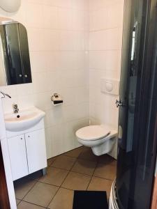 łazienka z toaletą i umywalką w obiekcie Pensjonat Tahiti w Rowach