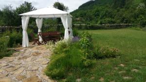a gazebo with a table and a bench in a field at Smart and Cozy Nature House in Belogradchik