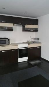 a kitchen with brown cabinets and a white stove top oven at Smart and Cozy Nature House in Belogradchik