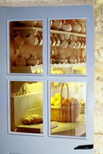a white cabinet with two windows and a basket of fruit at Casa do Castelo de Andrade in Puentedeume