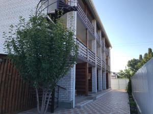 a house with a tree next to a building at Mini-hotel Zefir in Zatoka