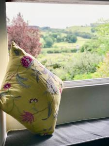 a pillow sitting on a window sill with a view at Old School House in Hawkshead