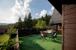 un patio con una mesa y sillas en el césped en Willa Karolinka Stróża - Pet Friendly, en Myślenice