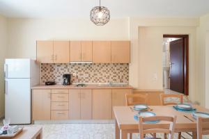 a kitchen with a table and a white refrigerator at Villa Karydies in Limenas