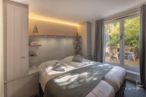 a bedroom with a bed and a window at Hotel Bilderdijk in De Haan