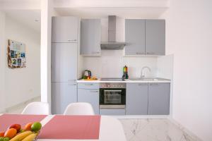 eine Küche mit weißen Schränken und einem Tisch mit einer Schale Obst in der Unterkunft Apartment Maja in Pula