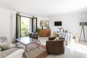 a living room with couches and a table and a television at Domaine Sesquier Mas d'exception Belle de Nuit in Mèze
