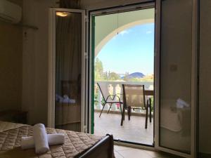 a bedroom with a sliding glass door leading to a patio at Mersina Apartments in Keri