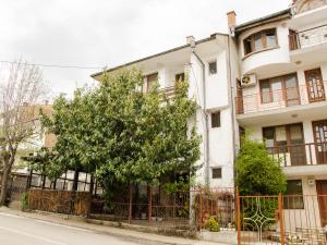 a white building with a tree in front of it at Дом Колеви in Chernomorets