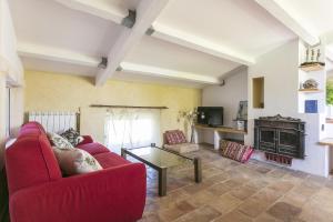 a living room with a red couch and a fireplace at Domaine Sesquier Mas d'exception Acacia in Mèze