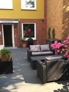 een patio met banken en bloemen voor een gebouw bij Dünenblick Apartments in Helgoland