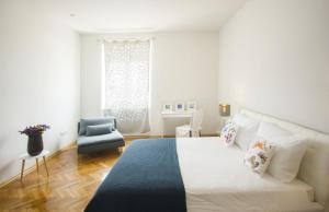 1 dormitorio blanco con 1 cama y 1 silla azul en La Bayadere, en Split
