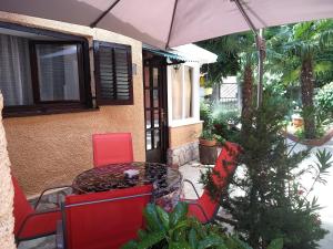 a patio with a table and chairs and an umbrella at Apartman Plasse in Rijeka
