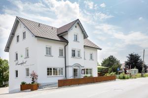 a white house with a black roof on a street at Gasthof Garni Knupfer in Ehingen