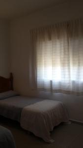 サンルーカル・デ・バラメダにあるCasa Algaidaのベッドルーム1室(窓の前にベッド2台付)