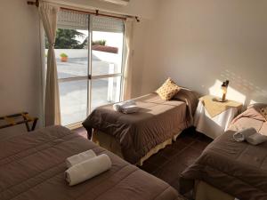 a room with three beds and a large window at Hotel Hermitage in Tandil +32 photos