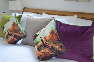 a bed that has a bunch of pillows on it at The Old Chapel Boutique B&B in Towcester
