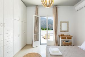 a white bedroom with a bed and a mirror at Sea-esta Beach House, By ThinkVilla in Balíon