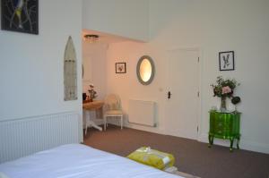 een slaapkamer met een bed, een tafel en een spiegel bij The Old Chapel Boutique B&B in Towcester