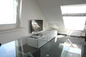 uma sala de estar com televisão e piso de vidro em Dünenblick Apartments em Helgoland