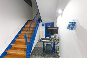 a staircase with a desk with a computer on it at Help Yourself Hostels - Parede in Parede